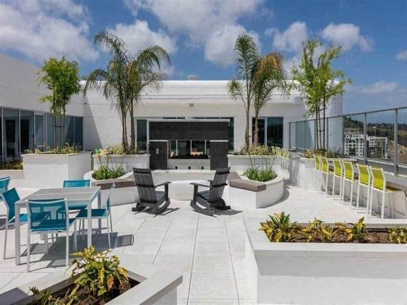 a large patio with tables and chairs and palm trees