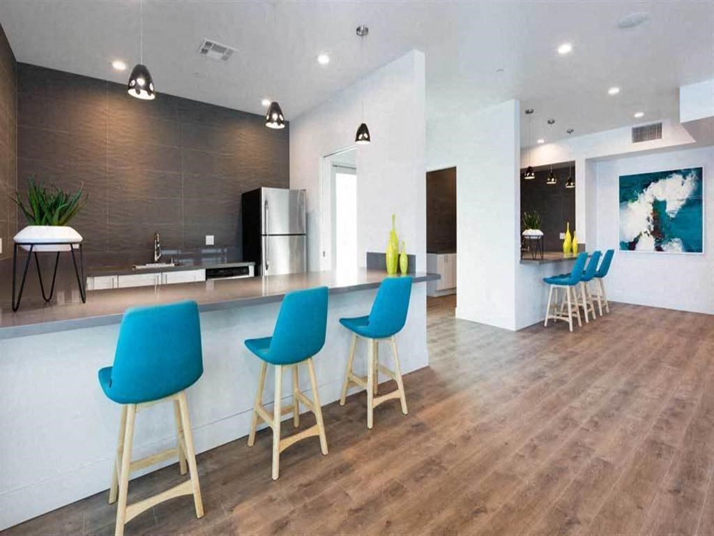 a kitchen and living room with blue chairs and a counter
