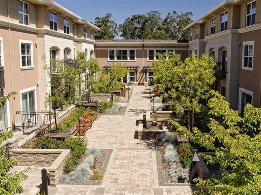Dog-Friendly Apartments in Novato CA - Millworks - Courtyard Garden with Benches, Seating Area, Fountains, and Lush Greenery.