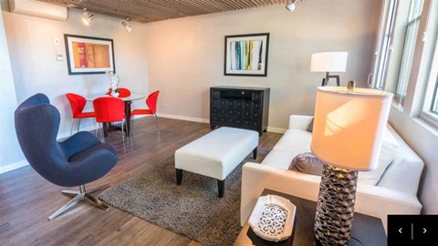 A living room with a black chair and a white couch.