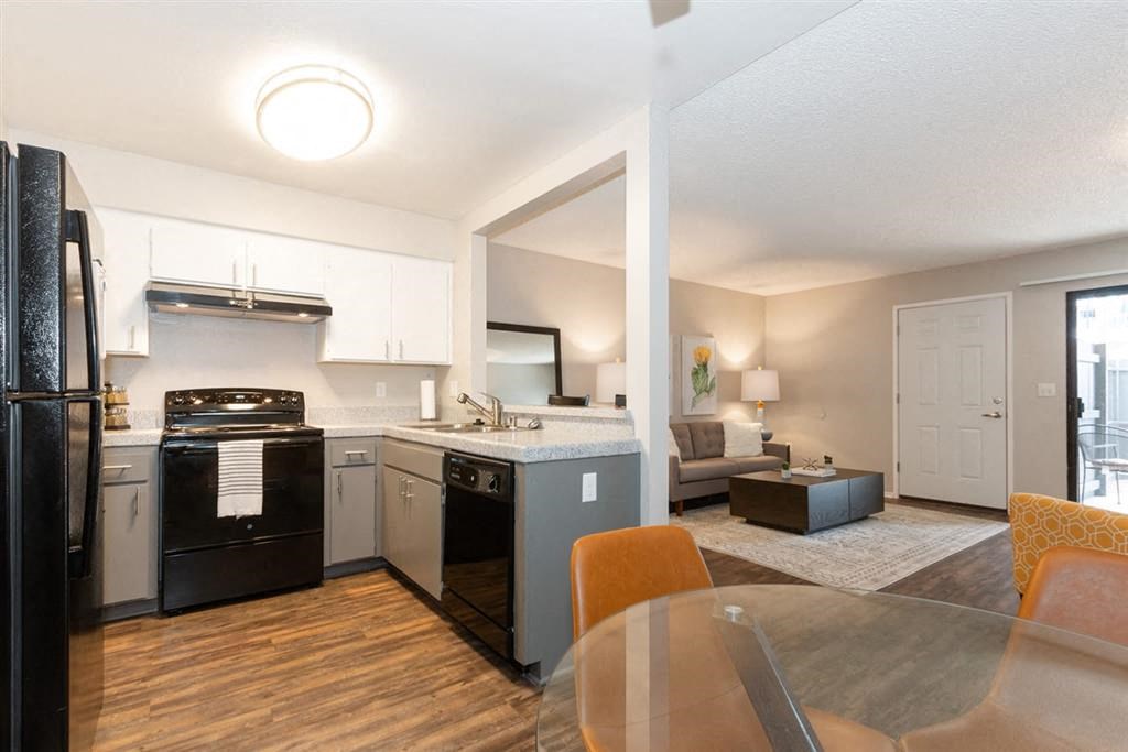 Pet Friendly Apartments in Riverside, CA - Veranda Riverside - Kitchen with Quartz-Style Countertops, Black Appliances, and Wood-Style Flooring