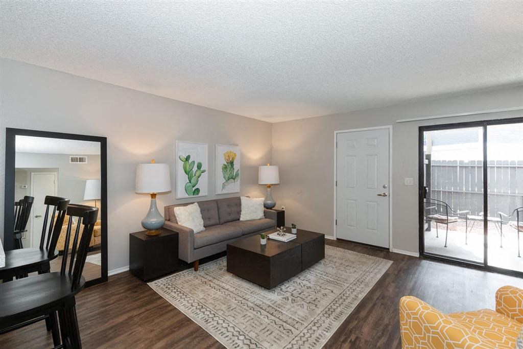 Apartments Riverside, CA - Veranda Riverside - Spacious Living Room with Couch, Coffee Table, End Tables, Lamps, Chair, Area Rug, and Large Sliding Glass Door to Private Patio.