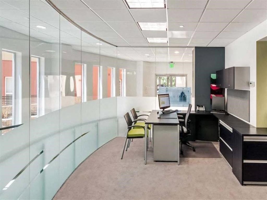 an office space with a desk and chairs and a computer