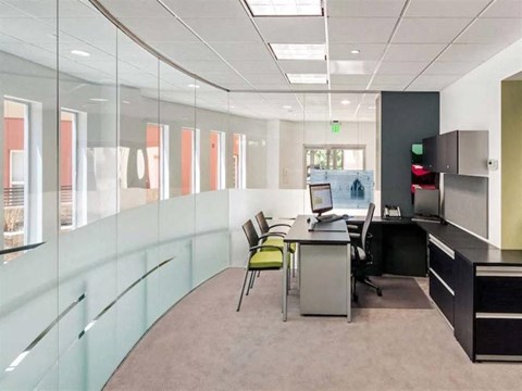 an office space with a desk and chairs and a computer