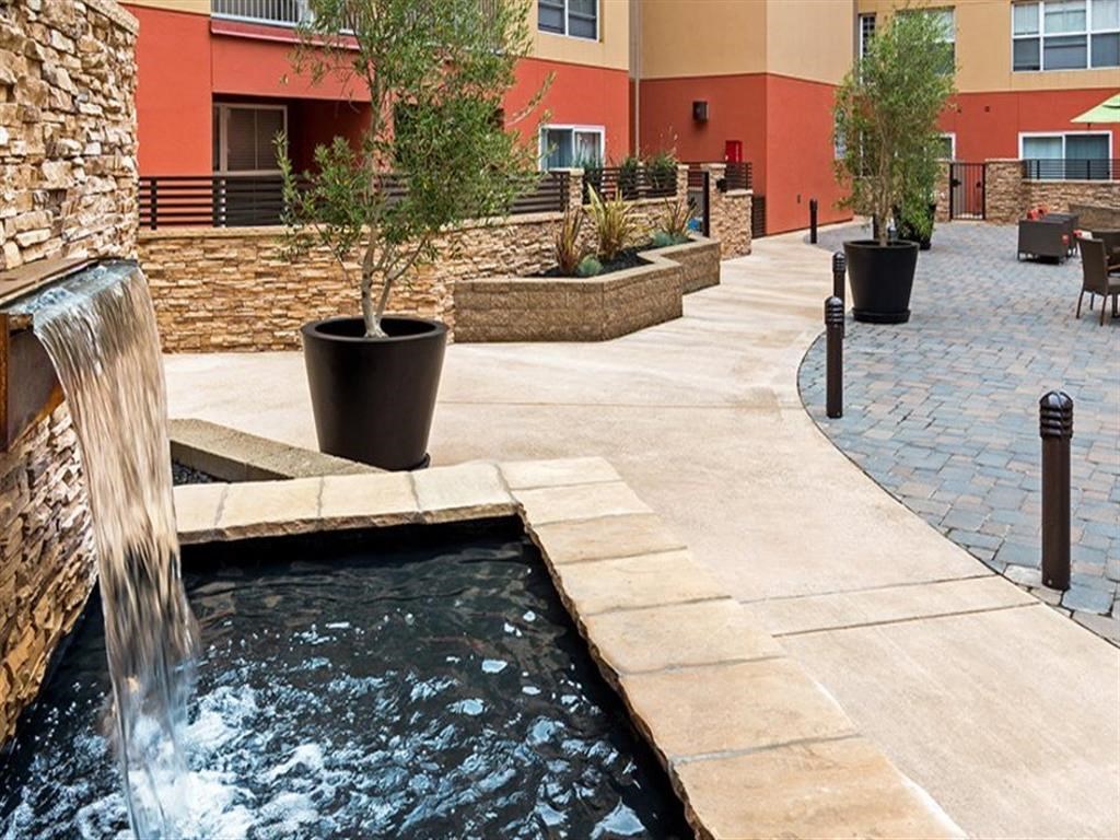 a pool with a waterfall in front of a building