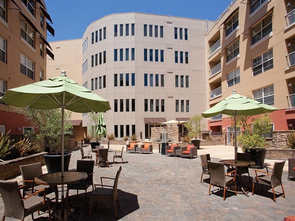 a courtyard with tables and chairs outside of a building