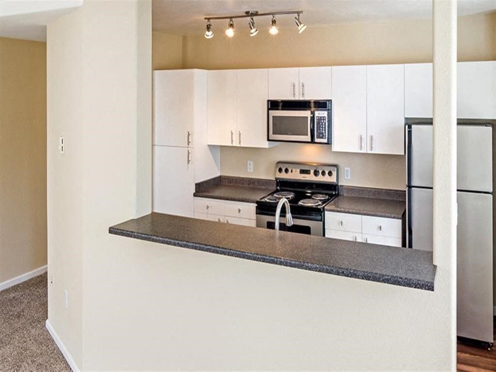 a kitchen with white cabinets and a counter top