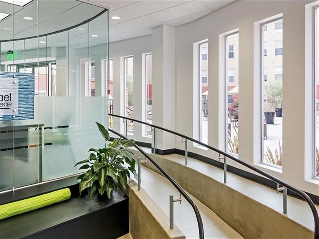the lobby of a building with an escalator and a plant