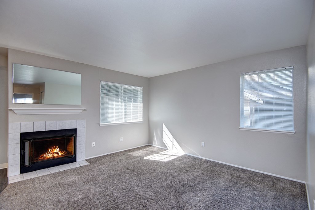 an empty living room with a fireplace and a window