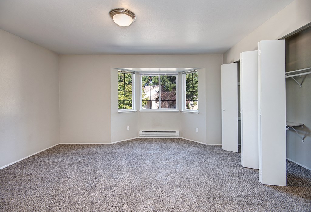 an empty room with a window and a closet