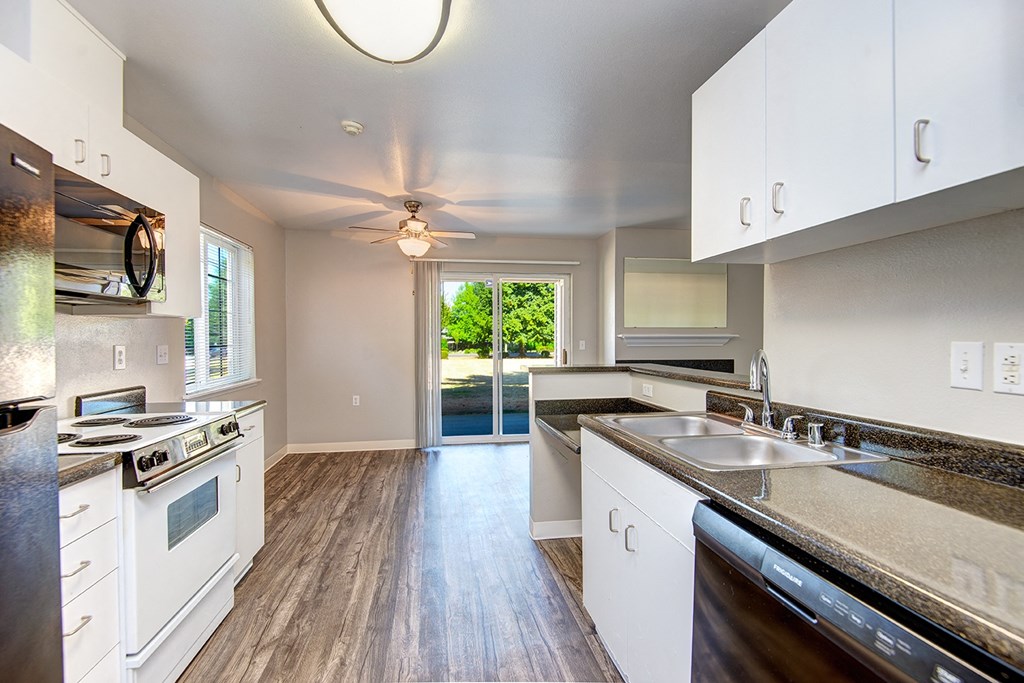 an empty kitchen with white cabinets and stainless steel appliances