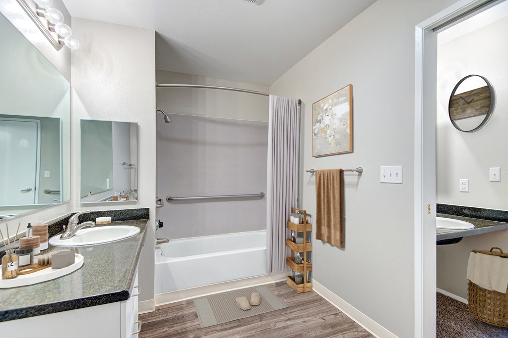 a bathroom with a tub and a sink and a mirror