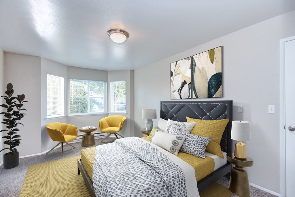 a bedroom with a bed and two yellow chairs