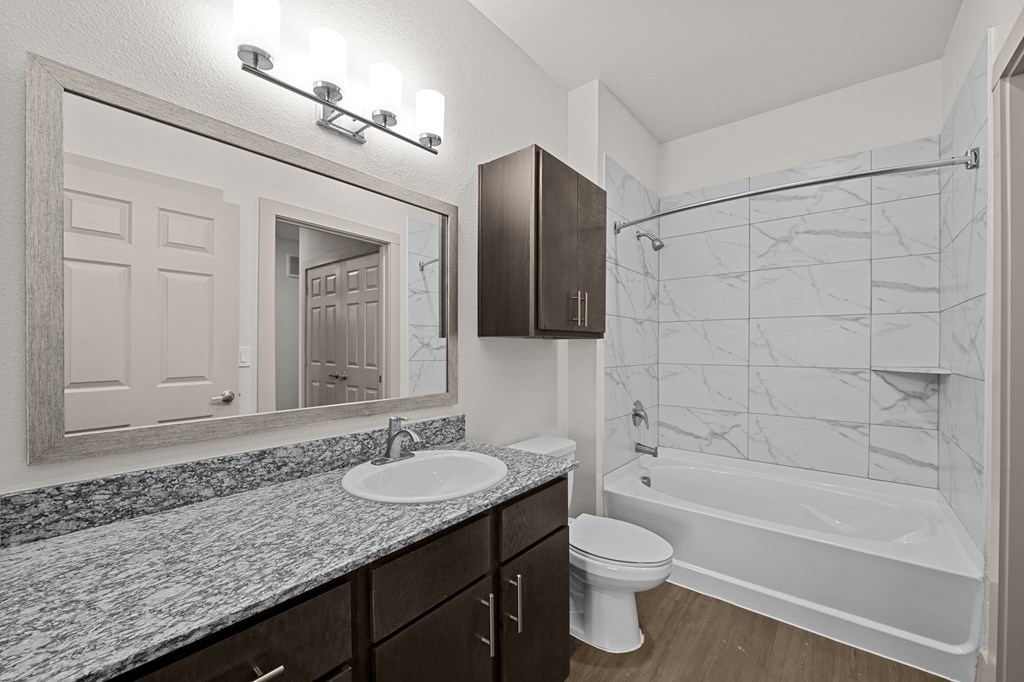 a bathroom with a shower sink and toilet and a mirror