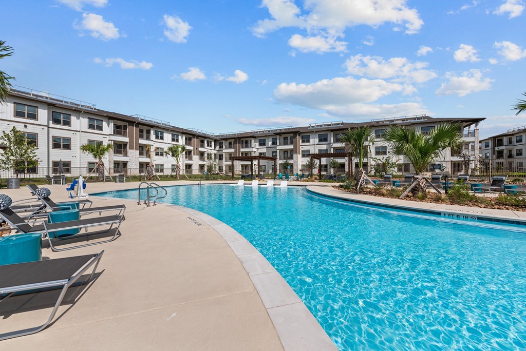 a large swimming pool with an apartment building in the background