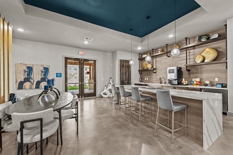 a kitchen with a bar and a dining room with chairs and a table
