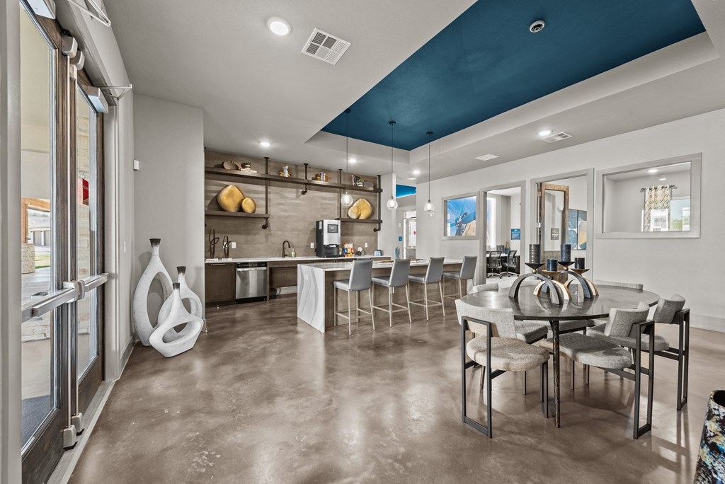 a clubhouse with a dining area and a kitchen with a table and chairs