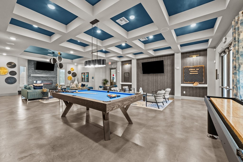a community room with a pool table and couches