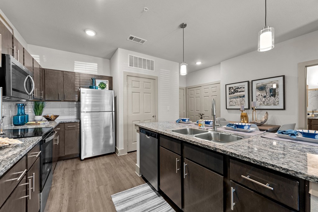 an open kitchen with stainless steel appliances and granite counter tops