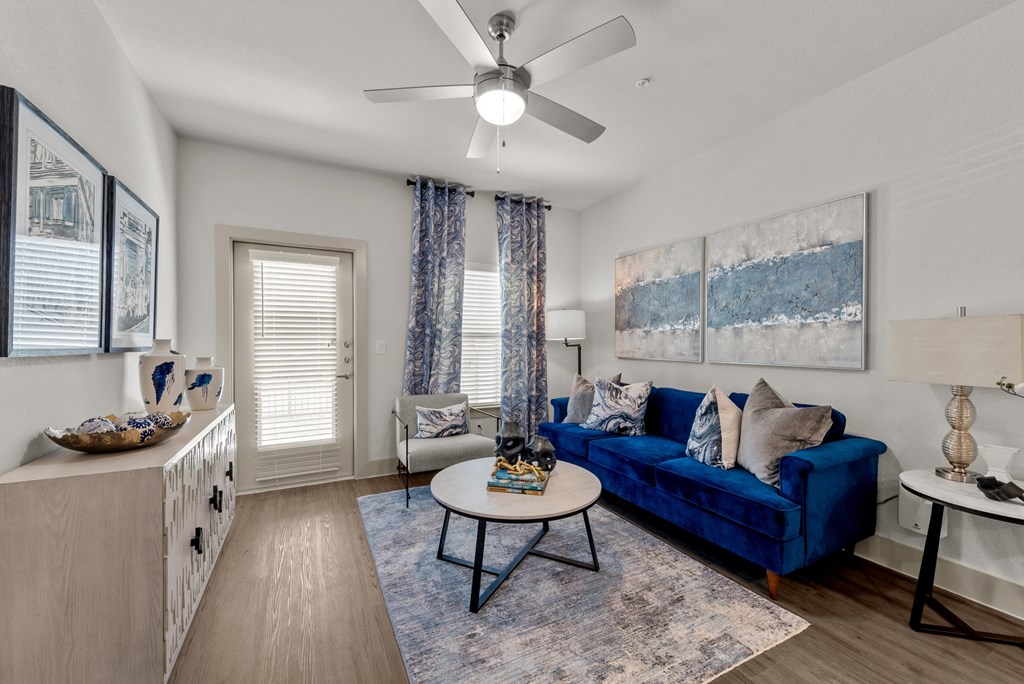 a living room with a blue couch and a ceiling fan