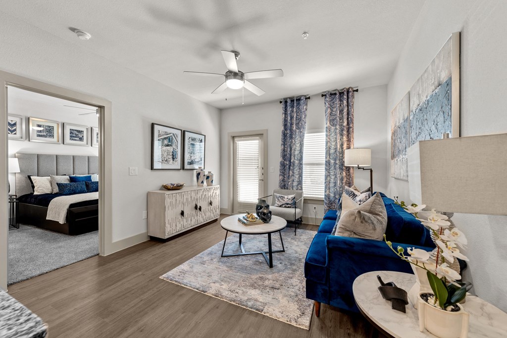 a living room with a blue couch and a ceiling fan