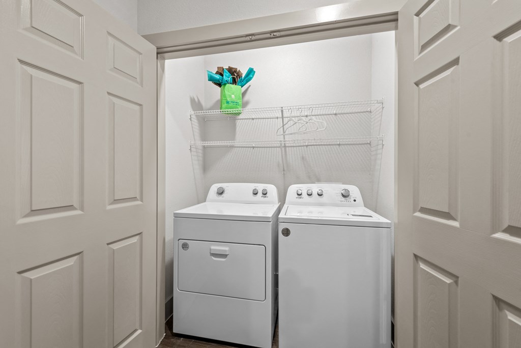 a washer and dryer in a laundry room with white appliances and white doors
