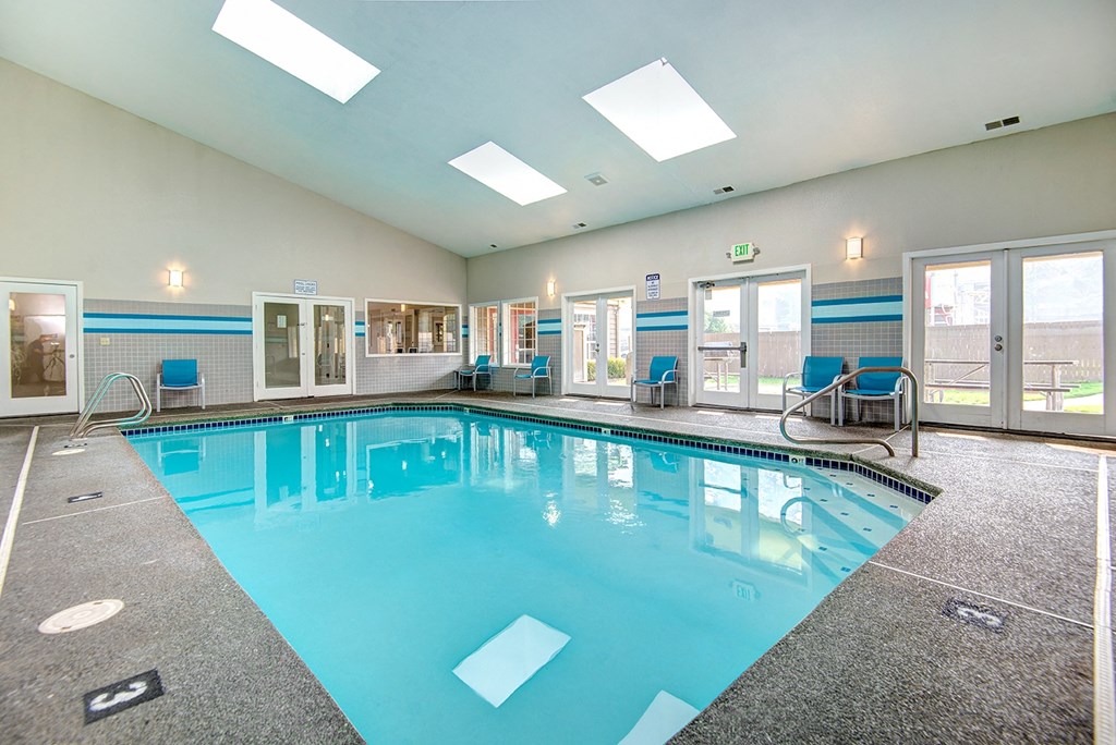 a swimming pool with chairs and a blue pool