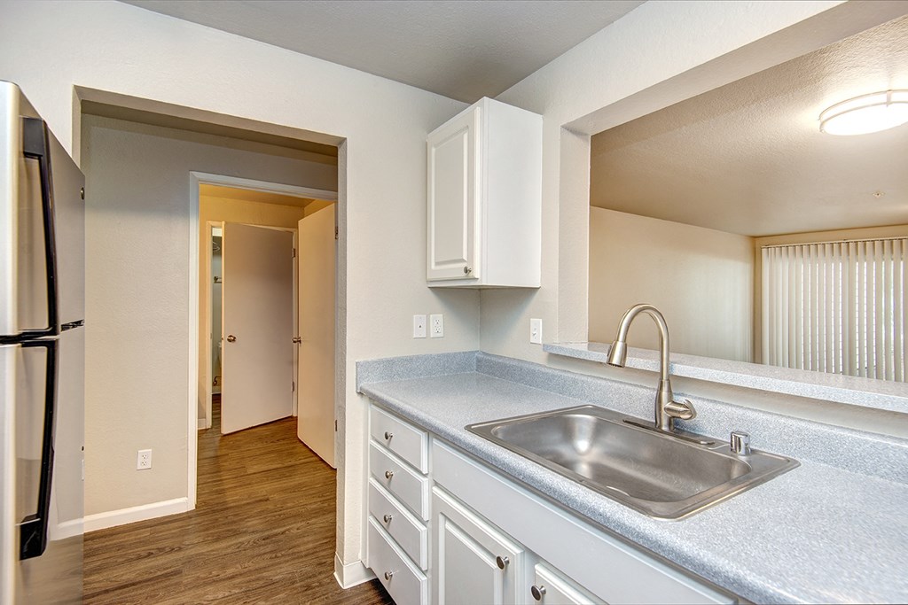 an empty kitchen with a sink and a refrigerator