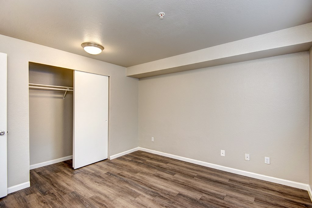 an empty living room with a door to a closet