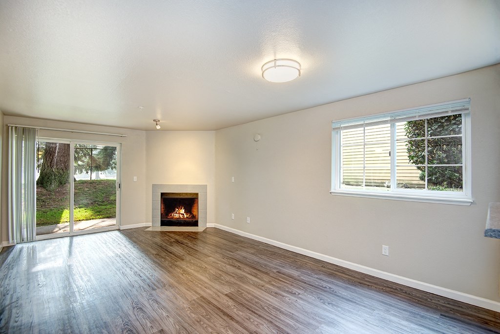 an empty living room with a fireplace and a sliding glass door