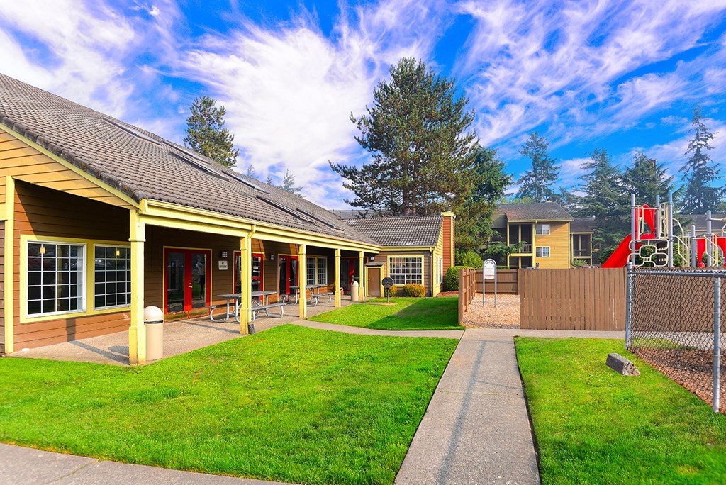 a building with a yard and a playground in front of it