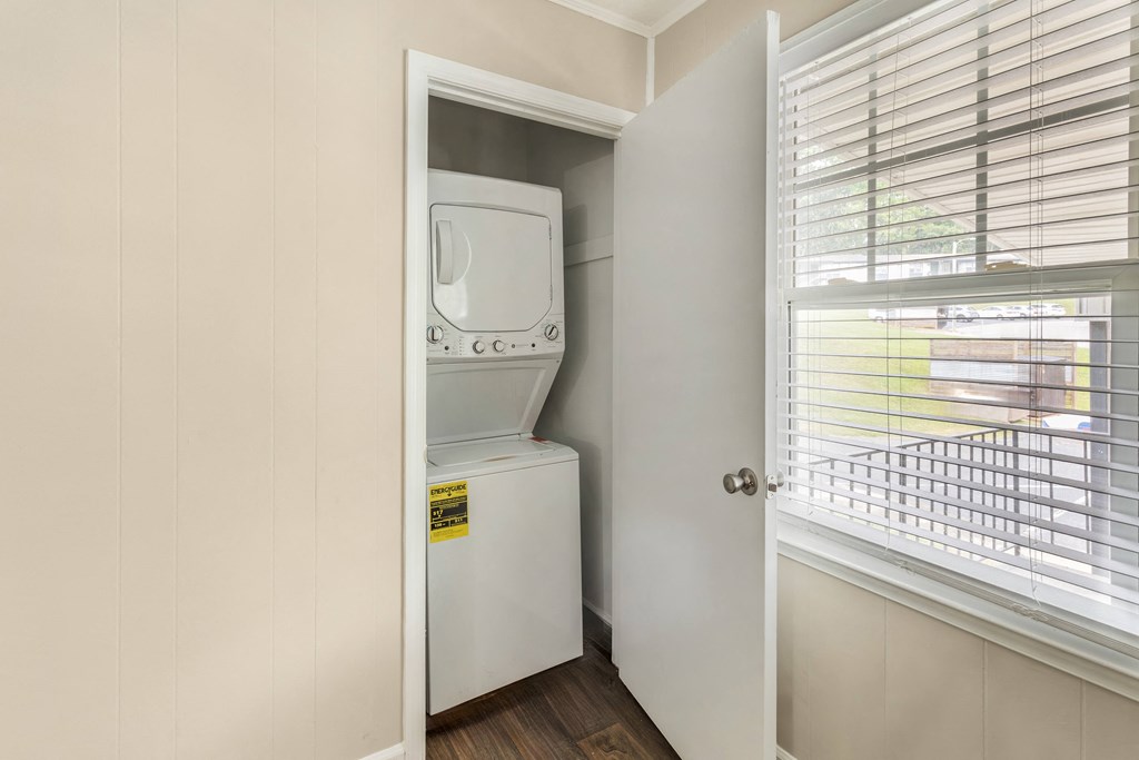 a small closet with a washer and dryer in it next to a window