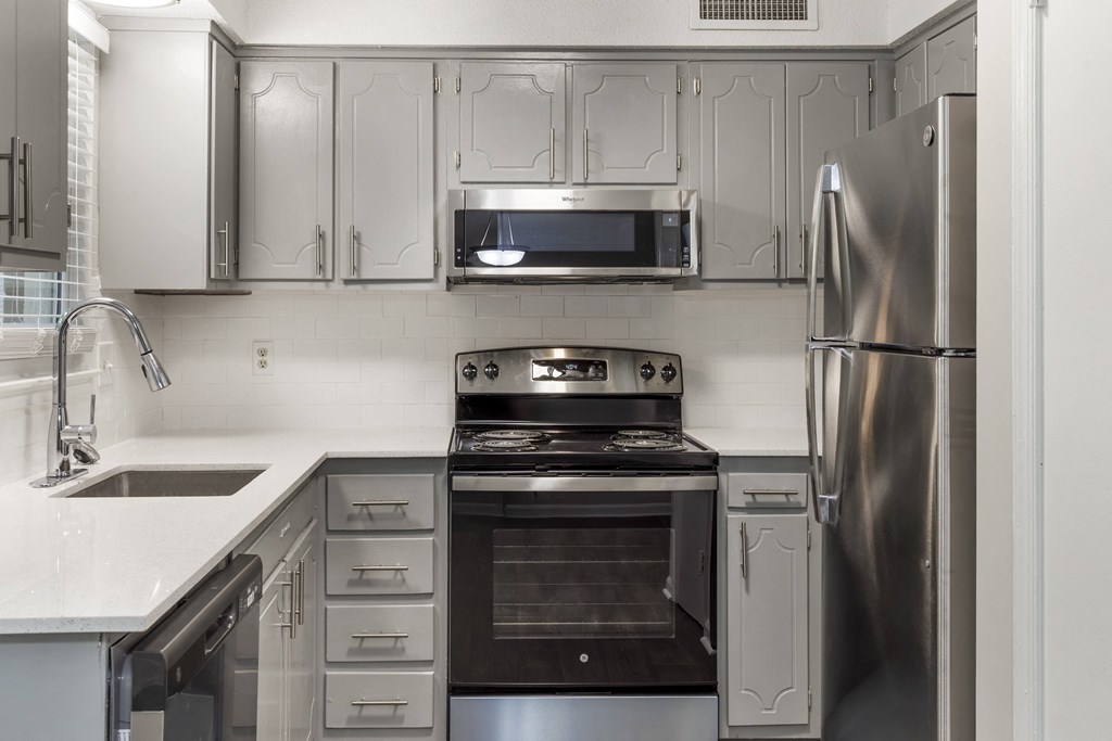a kitchen with stainless steel appliances and white cabinets
