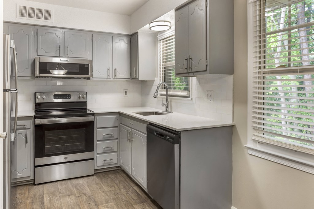 a kitchen with stainless steel appliances and white cabinets