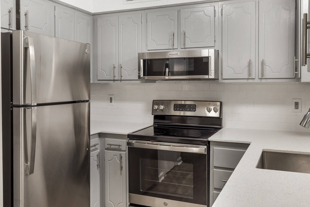 a kitchen with stainless steel appliances and white cabinets