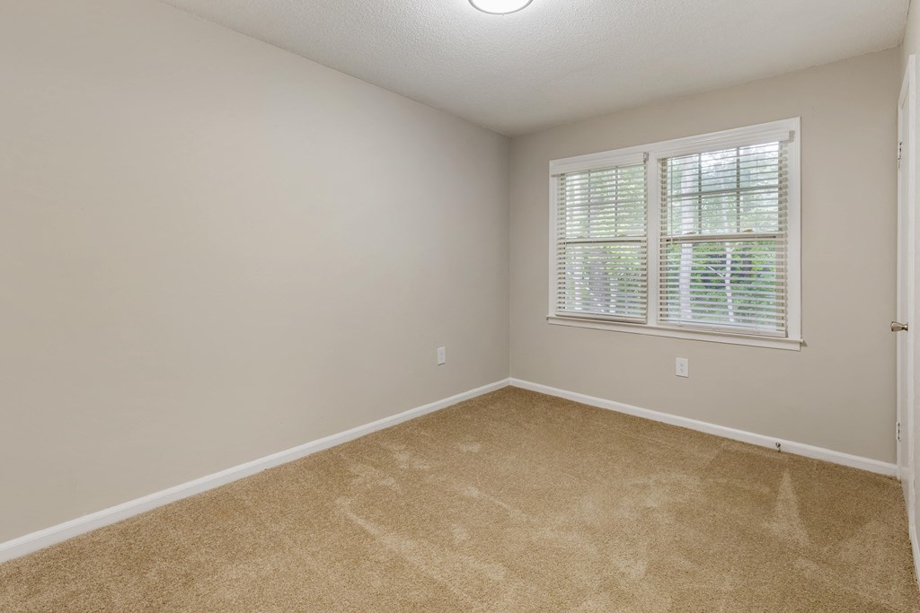 an empty room with carpet and a window