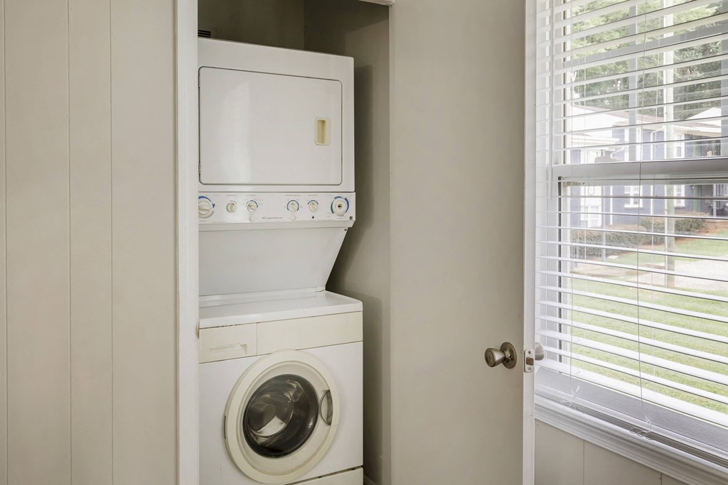 a white washer and dryer in a laundry room next to a window