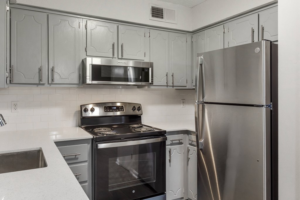 a kitchen with stainless steel appliances and white cabinets