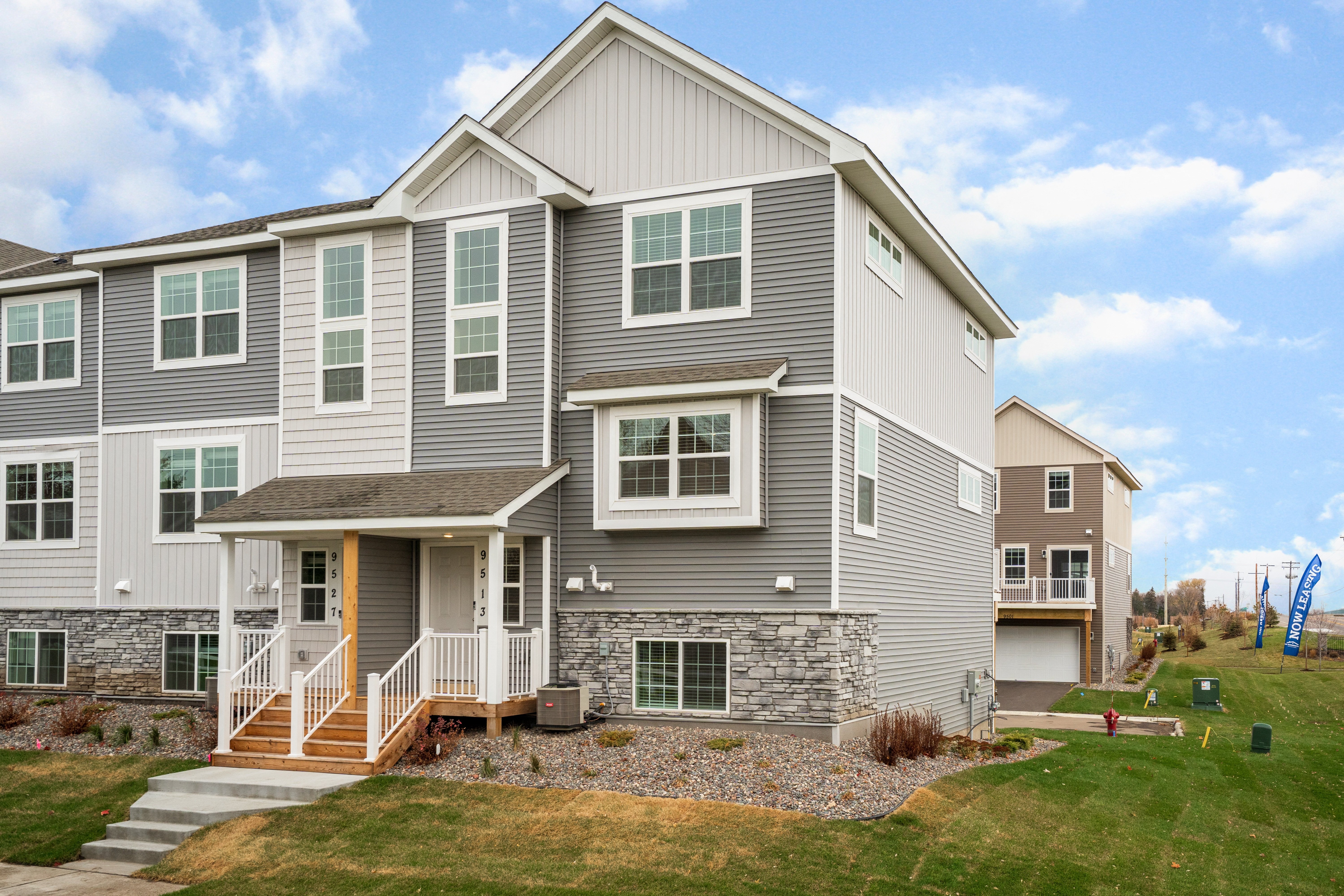 A grey house with a brown front porch.