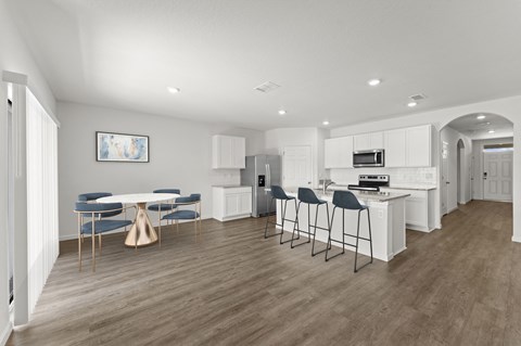 A modern kitchen with a dining table and chairs.
