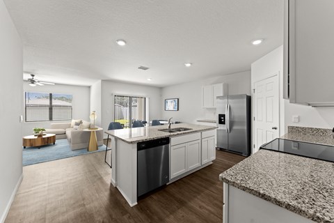 A modern kitchen with granite countertops and stainless steel appliances.