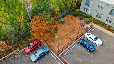 A parking lot with cars and a playground.