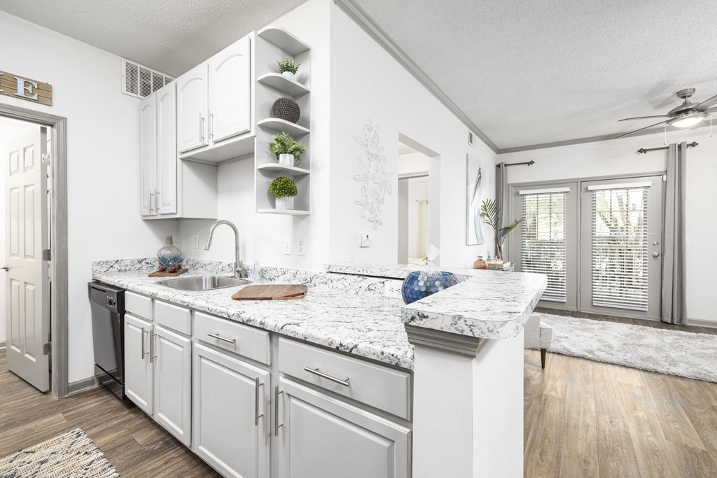 a kitchen with white cabinets and granite countertops