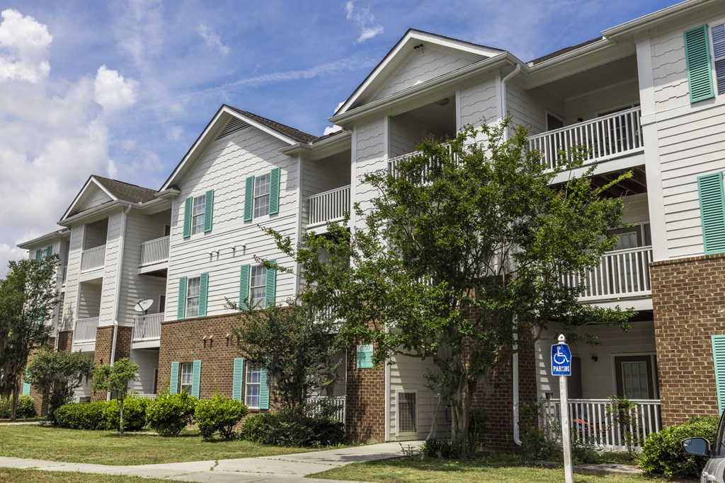 an apartment building with white siding and green shutters
