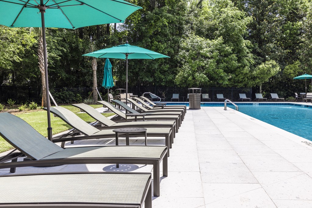 a pool with lounge chairs and umbrellas