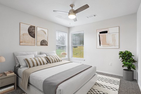 A bedroom with a large bed and a ceiling fan.