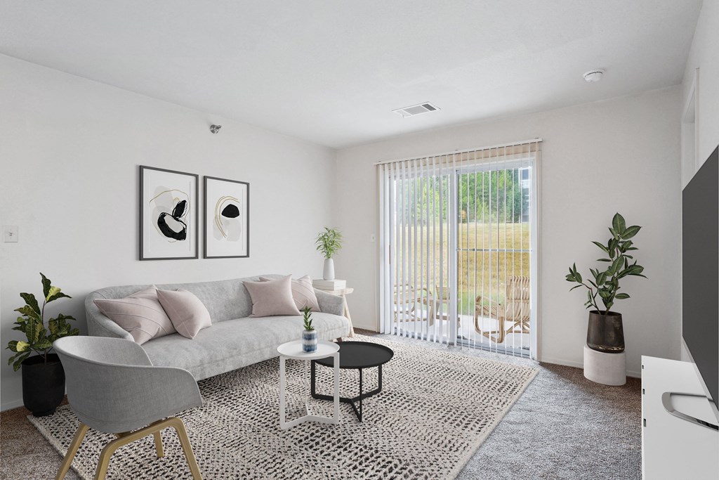 2 & 3-Bedroom Apartments for Rent in Little Rock, AR – Capitol Hill – A living room with a grey couch, a grey chair, a black and white coffee table, and a large window with blinds.