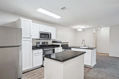 A kitchen with white cabinets and appliances.