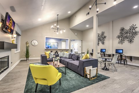 A modern living room with a yellow chair and a grey couch.
