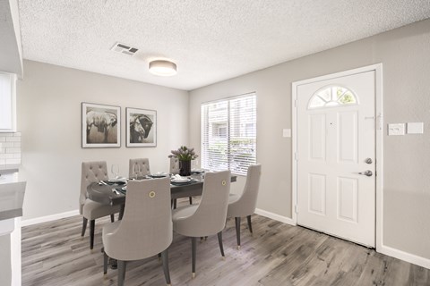A dining room with a table set for six.